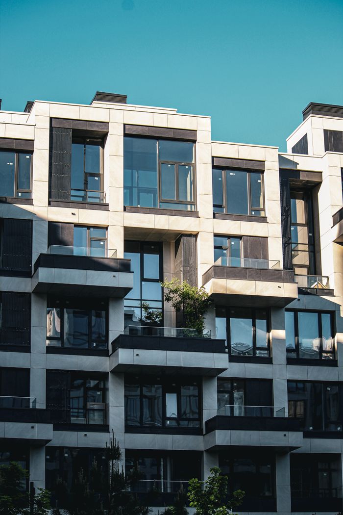 Contemporary apartment building facade with balconies and clear blue sky.