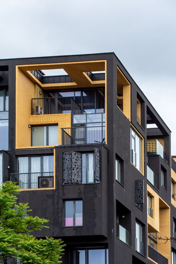Stylish modern apartment building featuring bold geometric design and contrasting colors, reflecting contemporary urban architecture.